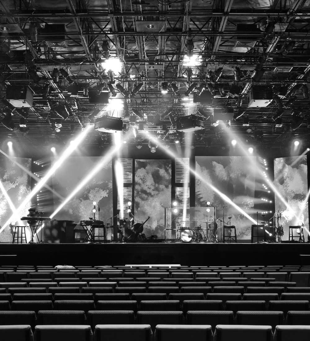 Large stage set for a live event with concert-style lighting and sound system produced by Pixl Production.